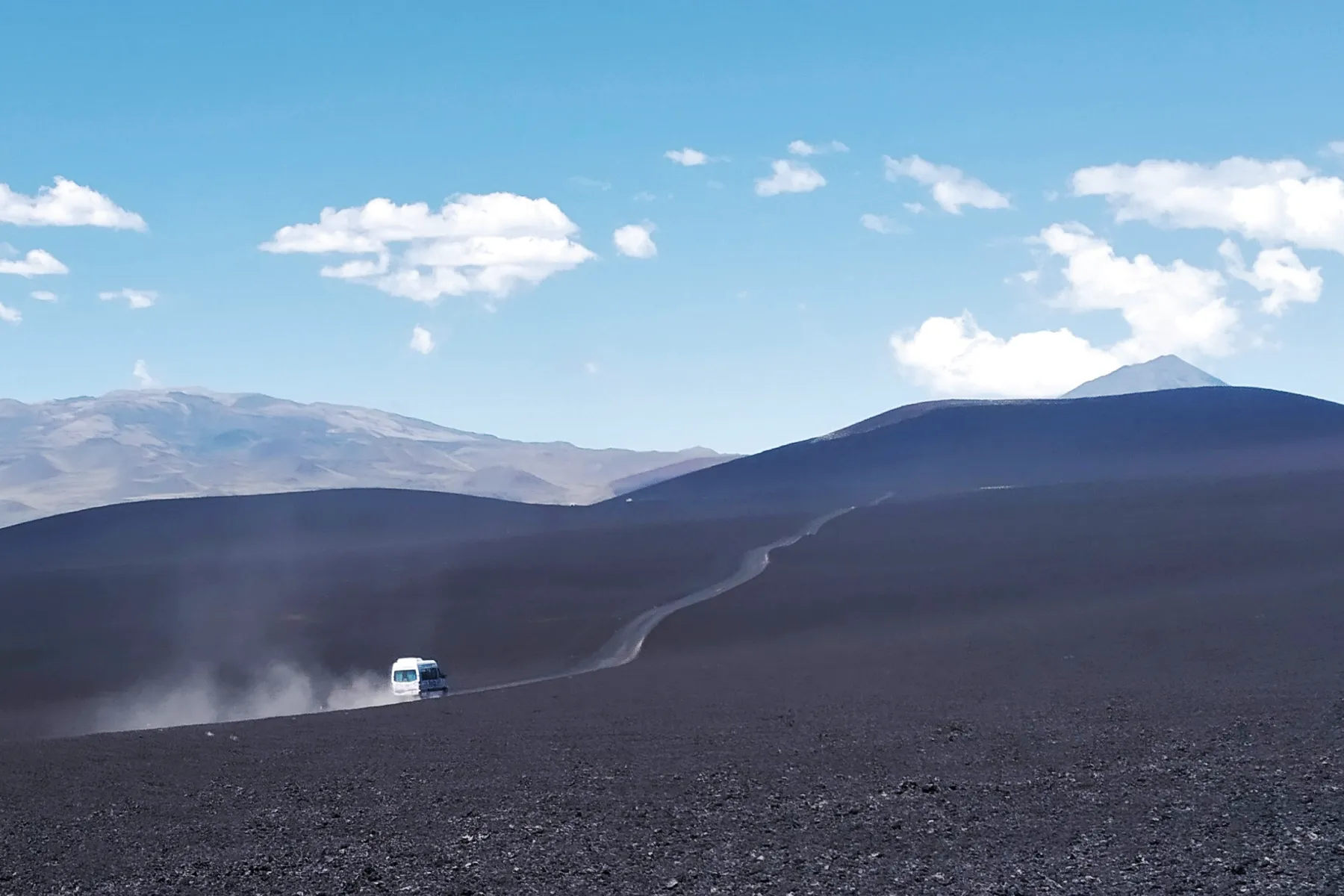 Unidad de Expreso Payún circulando por un camino de terreno volcánico
