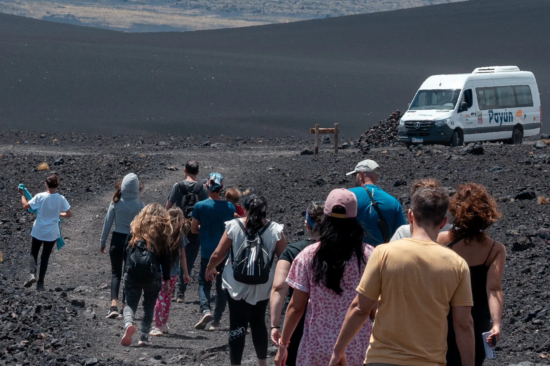 Grupo de pasajeros y unidad de Expreso Payún en La Payunia